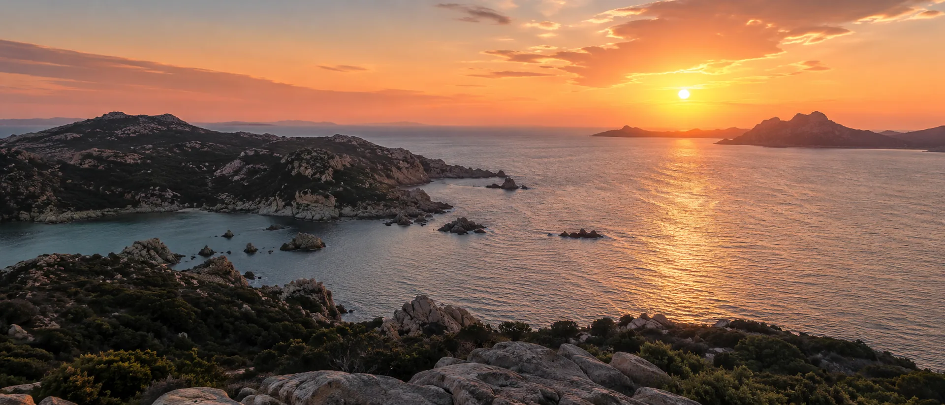 Sunset over the Sardinian coastline, rocky islands and open Mediterranean water.