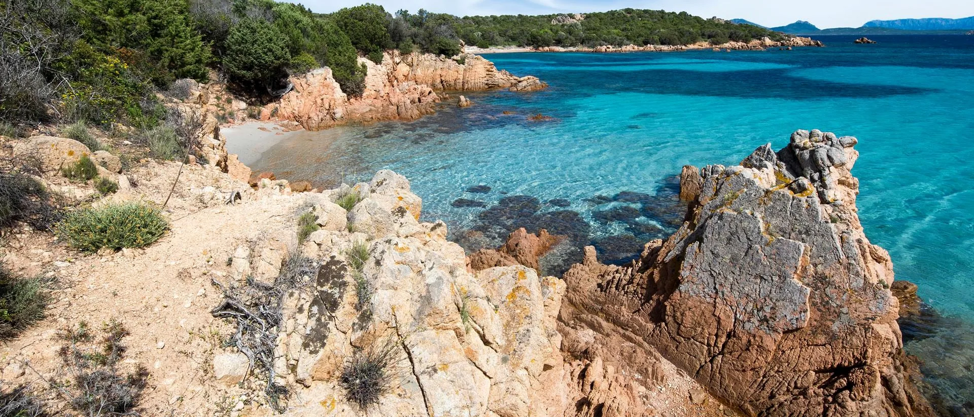 Wild Costa Smeralda coastline with granite, turquoise sea and open sky.